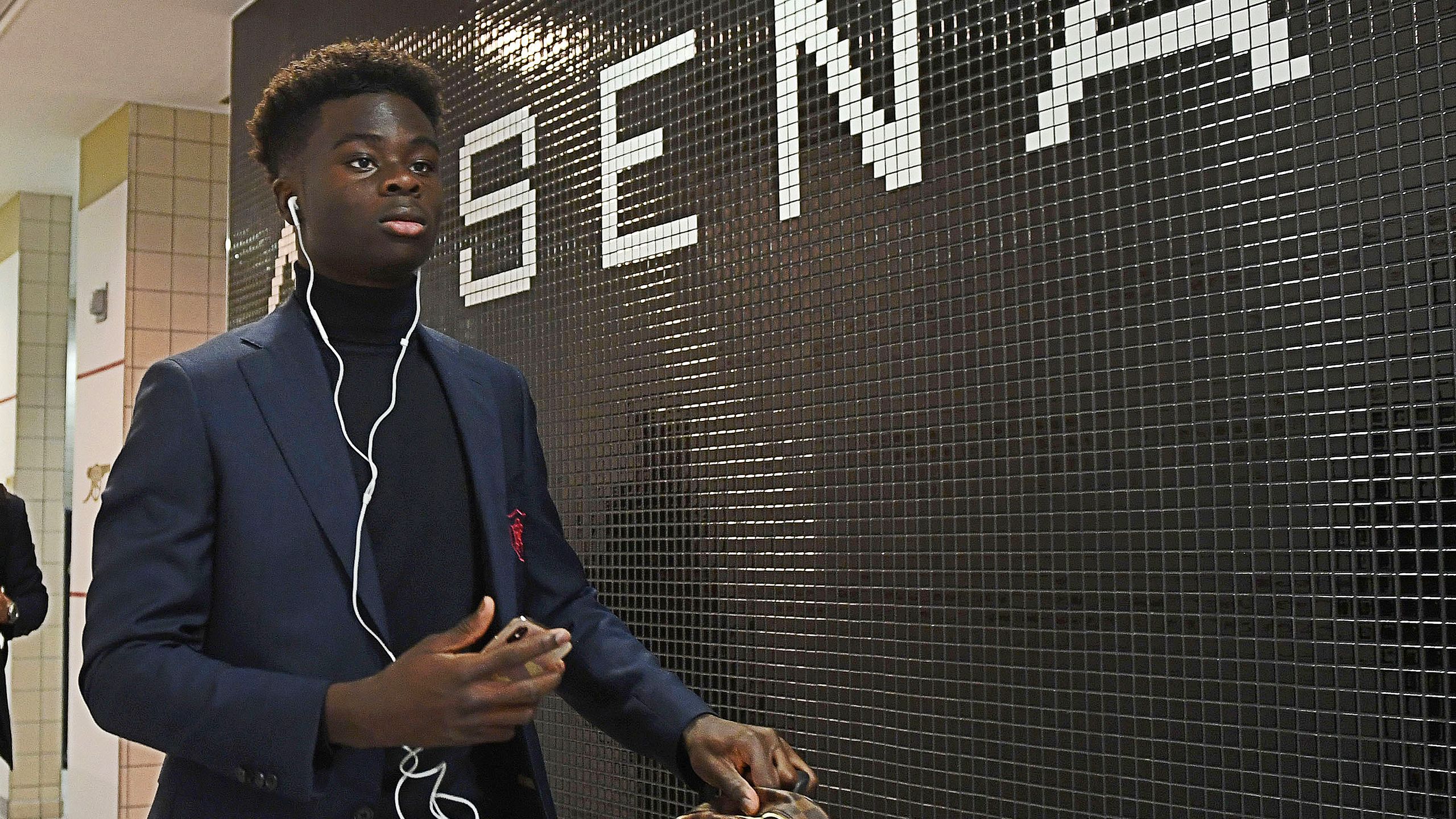 Bukayo Saka arrives in the Arsenal dressing room at Emirates Stadium