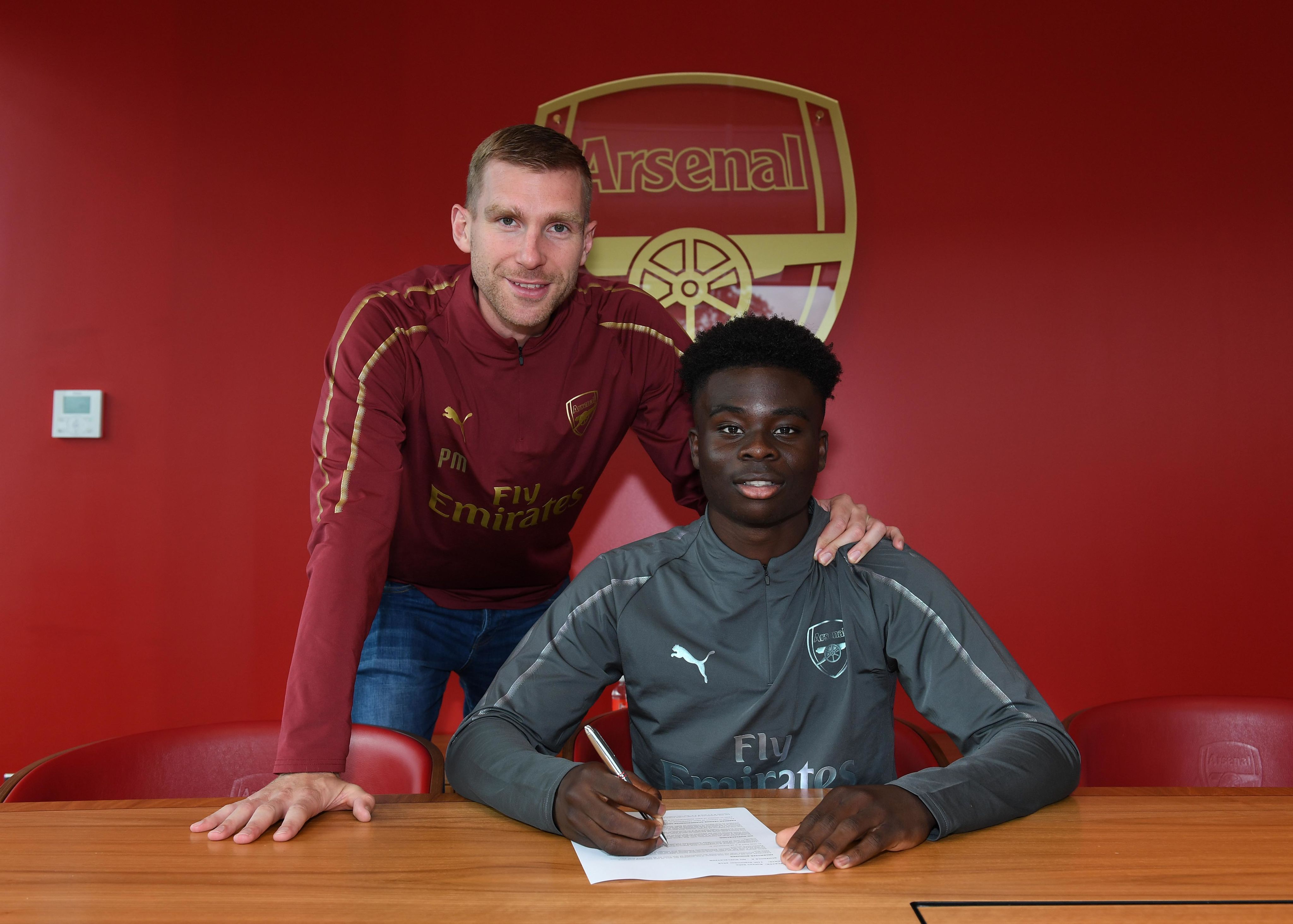 Bukayo Saka signs his first professional contract in the presence of academy manager Per Mertesacker