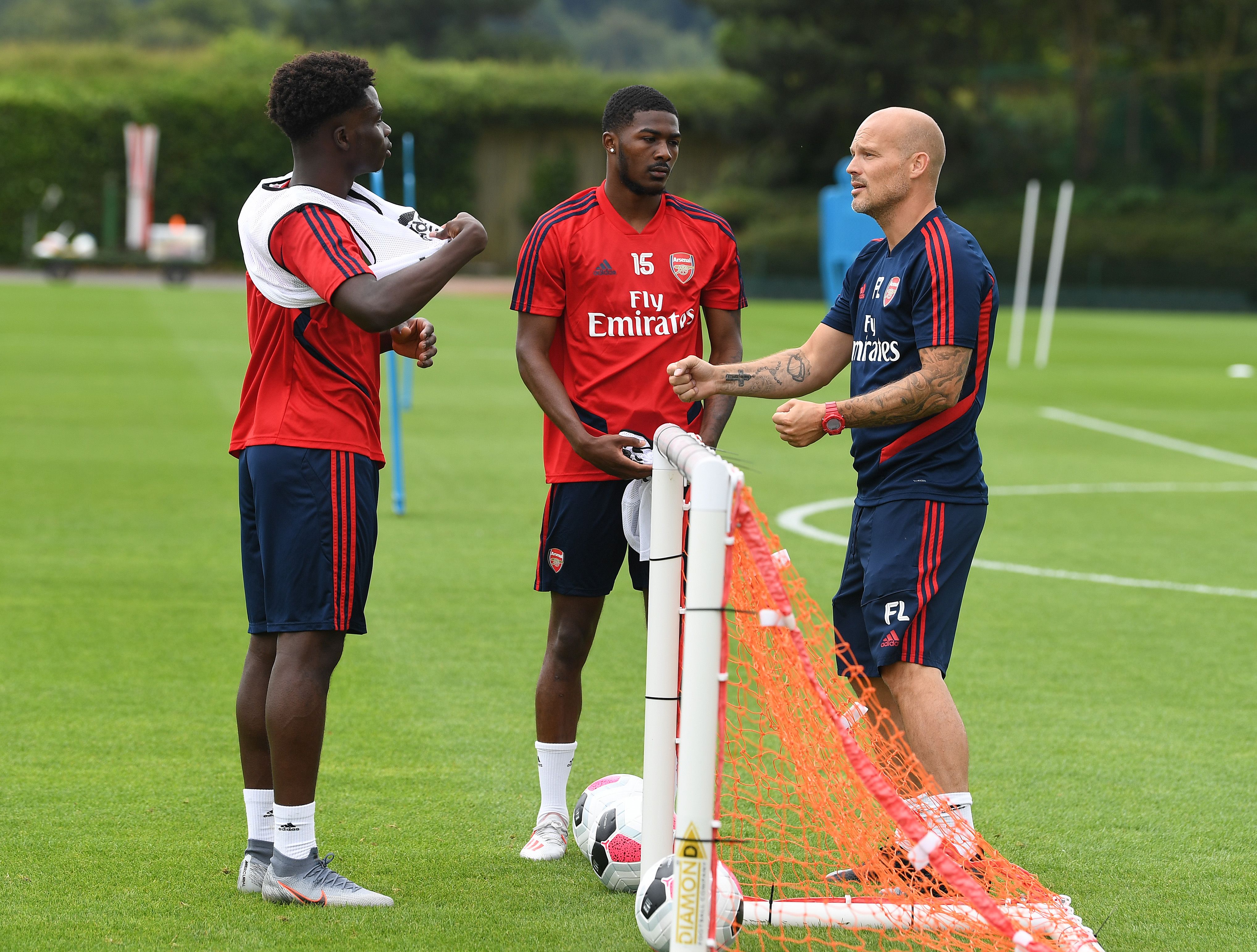 Freddie Ljungberg talks to Buyako Saka and Ainsley Maitland-Niles during a training session