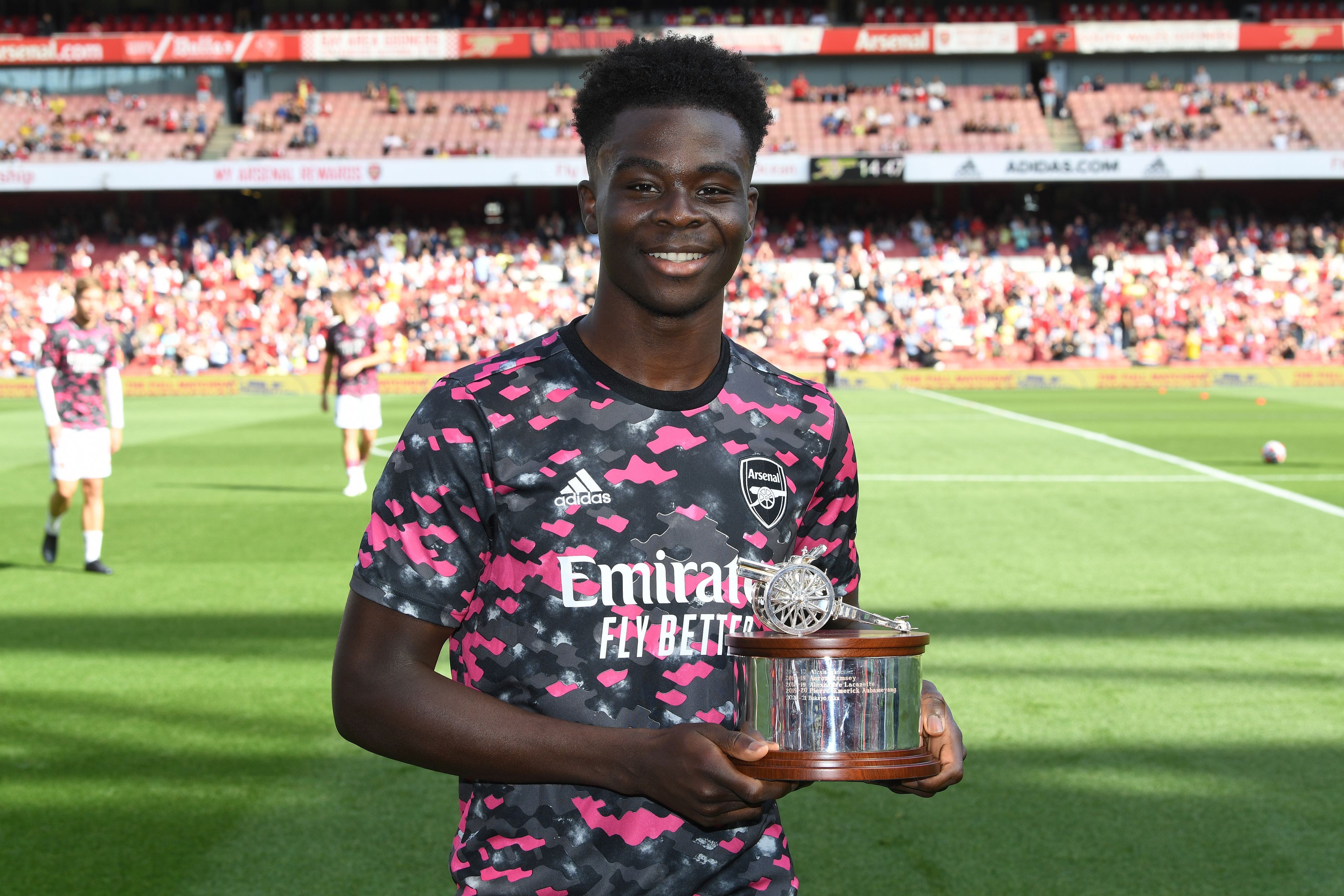 Bukayo Saka poses with the Arsenal Player of the Season award at Emirates Stadium