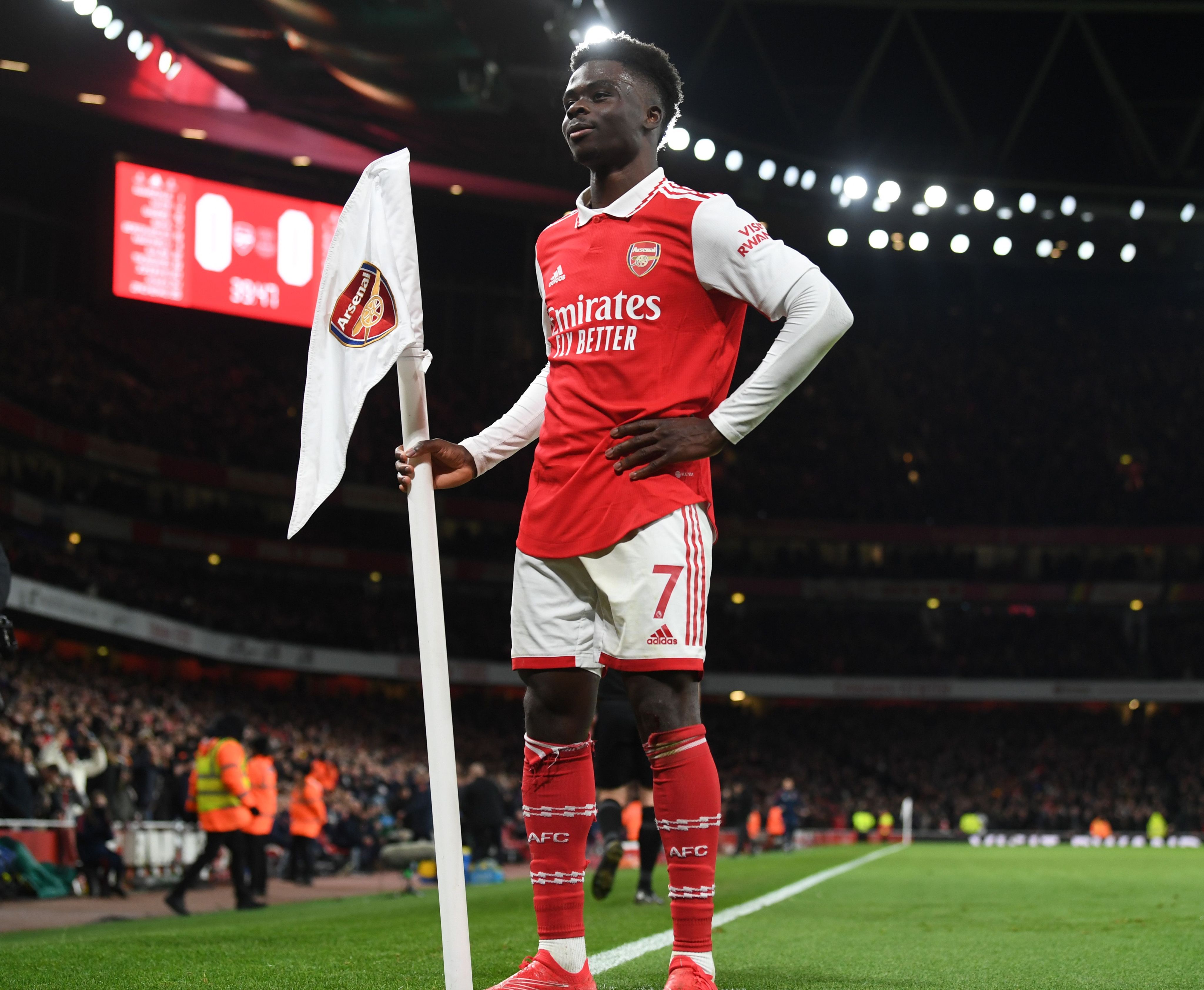 Bukayo Saka celebrates scoring against Everton at Emirates Stadium by holding the corner flag